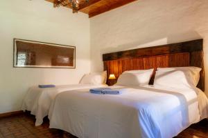 サン・アントニオ・デ・アレコにあるEstancia La Cinacinaの白いシーツが敷かれた部屋にベッドが2つ