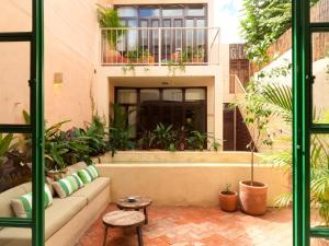 a patio with a couch and plants in a building at Kuka y Milpa in Mérida
