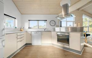a kitchen with white cabinets and stainless steel appliances at Amazing Home In Tarm With Sauna in Tarm