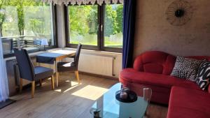 ein Wohnzimmer mit einem roten Sofa und einem Tisch in der Unterkunft Ferienwohnung Familie Boemer in Alf