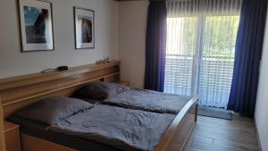 ein Schlafzimmer mit einem Bett und einem großen Fenster in der Unterkunft Ferienwohnung Familie Boemer in Alf
