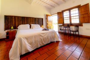 a bedroom with a large white bed in a room at Estancia La Cinacina in San Antonio de Areco