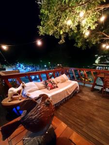 a bed on a deck with a statue of a bird at Pousada Praiana Jericoacora in Jericoacoara +52 photos