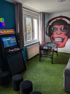 a room with a video game console and a game table at Les jardins de Romy in Calais +11 photos