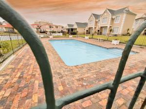 a swimming pool in a yard with houses at Dune Whispers in Jeffreys Bay