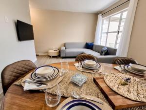 a dining room with a table and chairs and a couch at Dune Whispers in Jeffreys Bay