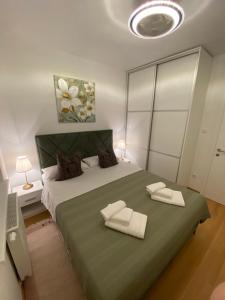 a bedroom with a large bed with two towels on it at RED home in Banja Luka