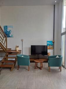a living room with a table and two chairs at TemporarioCasaLoft in Posadas