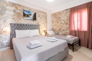 a bedroom with two beds and a window at Gkountis stone apartment 3 in Tsoukaladhes +21 photos