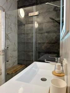 a bathroom with a white sink and a shower at ApartDirect Botanica 1 in Chişinău