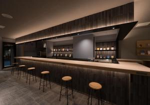 a bar with a row of stools in a restaurant at BOOKHOTEL Kyoto Kujo - Vacation STAY 97399v in Kyoto