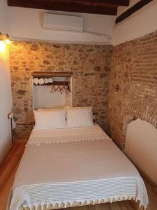 a bedroom with a bed in a brick wall at Tarihi Restore Edilmiş Rum Evi in Ayvalık