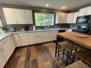 a kitchen with white cabinets and a wooden table at Cozy Getaway in Mullan in Mullan
