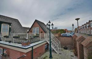 a house with a balcony and a street light at Westenwind in Egmond aan Zee