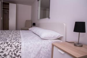 1 dormitorio con 1 cama y 1 mesa con lámpara en B&B Il Tramontano, en Matera