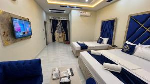 a hotel room with two beds and a flat screen tv at Hotel new royal palace in Lahore
