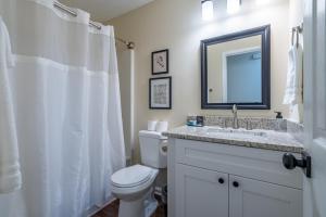 a bathroom with a toilet and a sink and a mirror at Affordable 4-Bedroom Retreat Near DT Cartersville in Cartersville +36 photos