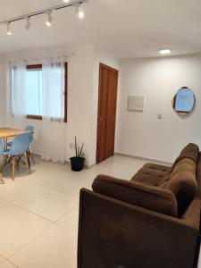 a living room with a couch and a table at Flat novo na Rua Principal, Itacaré BAHIA in Itacaré