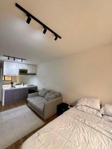 Un dormitorio con una cama y un sofá y una cocina. en Flat Moderno no Coração do Rio, en Río de Janeiro