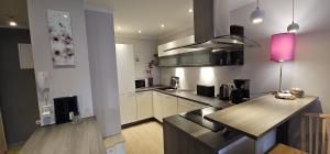 una cucina con mobili bianchi e una lampada rosa di Apartman Ana Maris a Fiume (Rijeka)