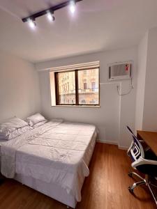 Un dormitorio pequeño con una cama y una ventana. en Flat Moderno no Coração do Rio, en Río de Janeiro 27 fotos más