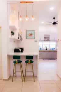 a kitchen with a counter and two stools at KotaSas Summer East Persint 5 by AHM Home in Kuantan