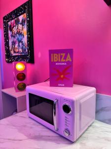 a pink room with a microwave with a box on top at Maison 60 m2 Loveroom romantique avec jacuzzi privé à 10 min de Nancy et jardin privé in Messein