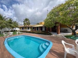 a swimming pool with chairs and a house at Casa Mares in Estância