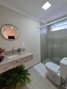 a bathroom with a toilet and a sink and a shower at Acolhedor ao lado de Vinícola e Centro in Espirito Santo Do Pinhal