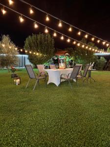 a table and chairs in a yard with lights at Guest House Doni in Sandanski +56 photos
