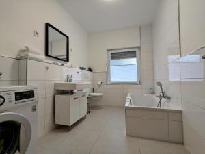 La salle de bains blanche est pourvue d'un lavabo et d'un lave-linge. dans l'établissement 55qm Messe Wohnung, Trade Fair, 6 Minuten zur Messe, à Rheinstetten 20 autres photos