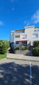 un grande edificio bianco sul lato di una strada di Apartman Ana Maris a Fiume (Rijeka)