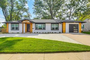 a house with a driveway in front of it at Stylish and Modern Lenexa Haven with Fire Pit and Deck! in Lenexa