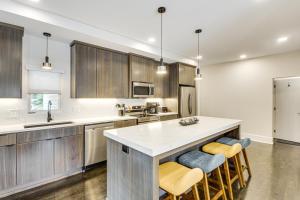 a kitchen with wooden cabinets and a white counter top at Stylish and Modern Lenexa Haven with Fire Pit and Deck! in Lenexa