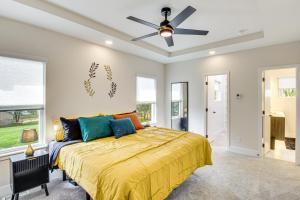 a bedroom with a bed and a ceiling fan at Stylish and Modern Lenexa Haven with Fire Pit and Deck! in Lenexa