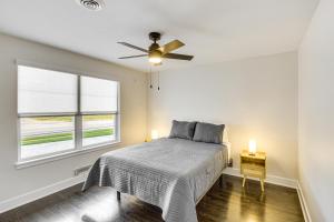 a bedroom with a bed and a ceiling fan at Stylish and Modern Lenexa Haven with Fire Pit and Deck! in Lenexa