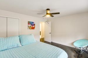 a bedroom with a bed and a ceiling fan at Stylish and Modern Lenexa Haven with Fire Pit and Deck! in Lenexa