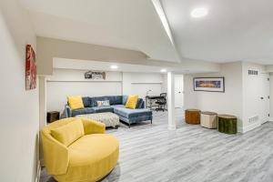 a living room with a couch and a chair at Stylish and Modern Lenexa Haven with Fire Pit and Deck! in Lenexa