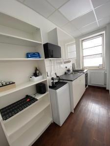 a small kitchen with white cabinets and a sink at City Nowa 1 in Nürnberg
