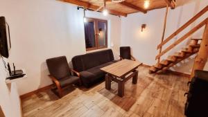 sala de estar con mesa, sofá y sillas en Leśna Przystań, en Busko-Zdrój