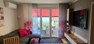 un soggiorno con un divano e una grande finestra di Apartman Ana Maris a Fiume (Rijeka)
