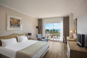 a hotel room with a bed and a balcony at IC Hotels Santai Family Resort - Kids Concept in Belek +37 photos