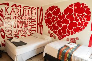 - 2 lits dans une chambre avec des cœurs sur le mur dans l'établissement Hostal Loco Coco Loco, à Panama City