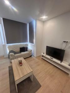 Una sala de estar con un televisor de pantalla plana y un sofá. en Padre Anchieta 35 - 5, en Santa Cruz de Tenerife