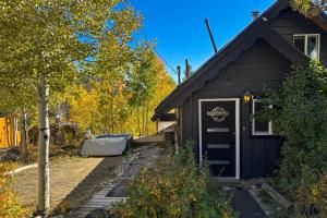 a house with a black door and a tree at The Golden Moose Chalet in Grand Lake