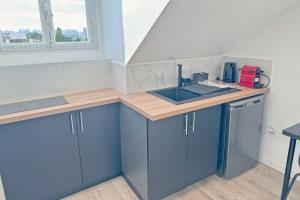 a kitchen with blue cabinets and a sink at Cozy Paris Gateway Studio with free parking in Vitry-sur-Seine +8 photos