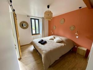 a bedroom with a bed with an orange wall at Domaine aux souvenirs denfance in Bénaix