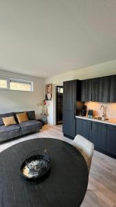 a living room with a black table and a kitchen at Dishoek by the Sea in Koudekerke
