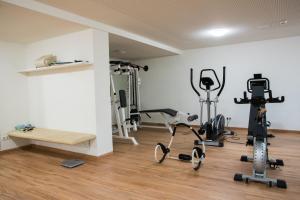 einen Fitnessraum mit Laufbändern und Trainingsgeräten in einem Zimmer in der Unterkunft Boutique Hotel Erla in Stubenberg