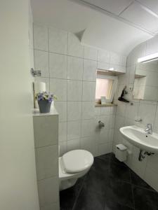 a white bathroom with a toilet and a sink at City Nowa 1 in Nürnberg +96 photos